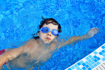 Obraz premium Boy swimming in a pool