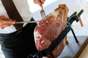 waiter slicing parma ham