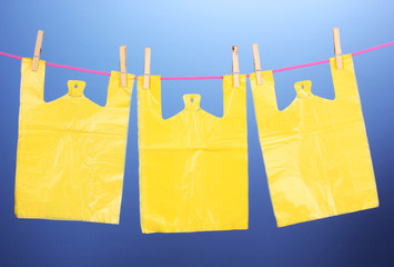 Cellophane bags hanging on rope on blue background