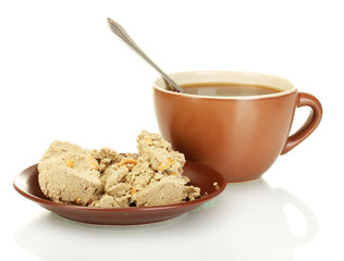 A cup of tea and saucer with delicious halva isolated on white