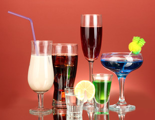 a variety of alcoholic drinks on red background