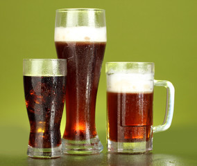 refreshments - beer, cola and kvass on green background
