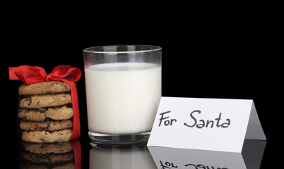 Glass of milk and cookies isolated on black