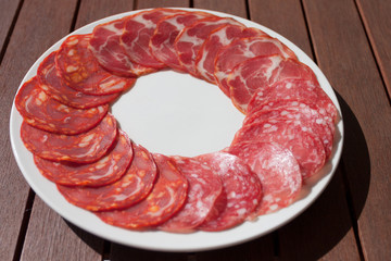 Salchichon, Chorizo and Cabecero sausage on white plate