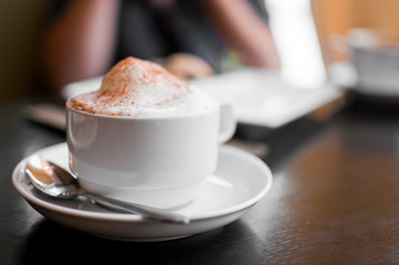 A cappuccino cup with milk foam and cinnamon