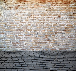 old brick wall with cobblestone street