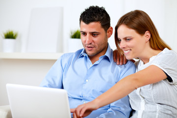 Fototapeta premium Charming young couple sitting on sofa