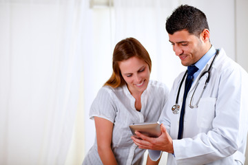 Handsome doctor and a woman looking to tablet PC