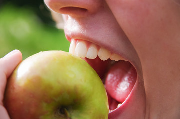 Junge Frau beißt in einen Apfel