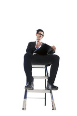 Businessman working on ladder