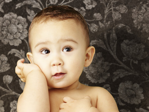 portrait of adorable kid posing against a vintage brown wall