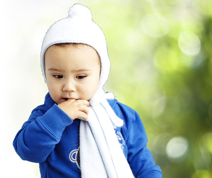 portrait of serious kid thinking with the finger on his mouth at