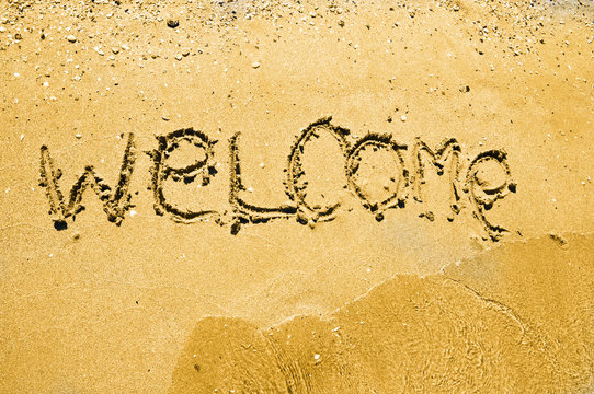 welcome written in a sandy tropical beach