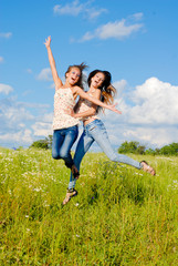 Two happy young women jumping