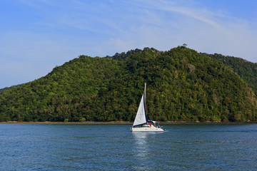 Одинокий парусник на фоне острова.