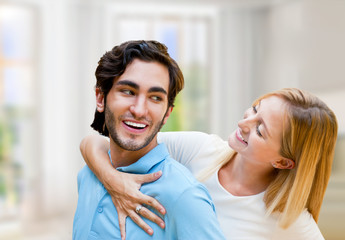 Cosy young couple embracing inside new apartment and planning to