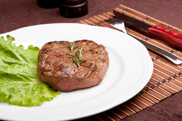 Grilled steak on a white plate