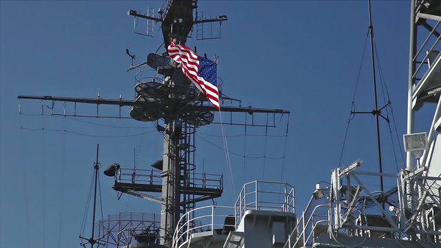 USA flag and antennas on carrier control tower in blue sky