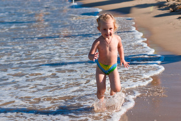 Little girl running along the beach