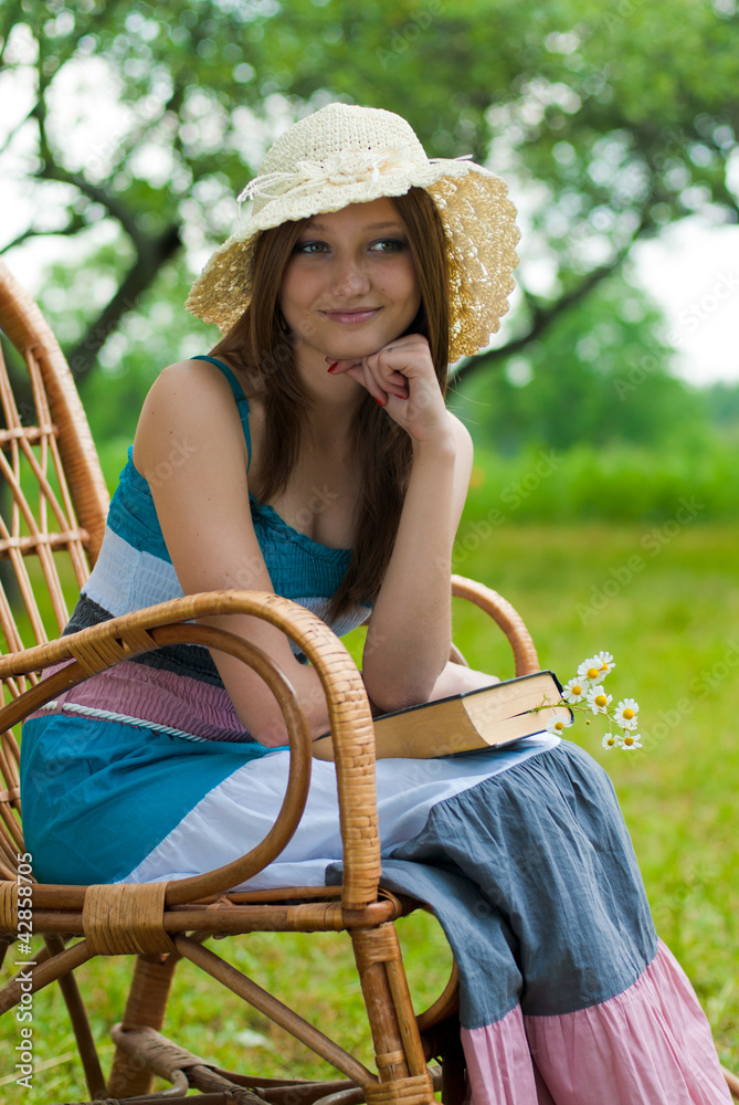 Wall mural beautiful woman resting outdoors and holding book