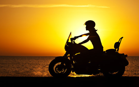 Fototapeta Woman biker over sunset
