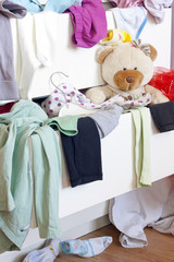 Messy kids room with clothes in drawer