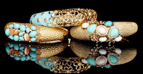 Beautiful golden bracelets with blue gems isolated