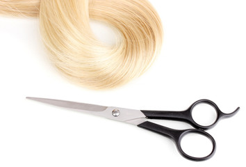 Shiny blond hair and hair cutting shears isolated on white.