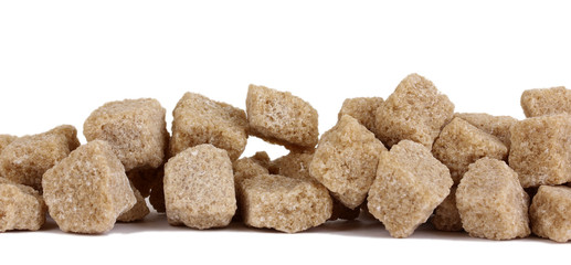 Lump brown cane sugar cubes isolated on white