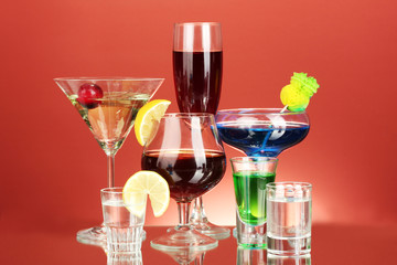 a variety of alcoholic drinks on red background