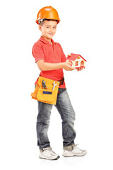 Full length portrait of a child with helmet holding a model of h