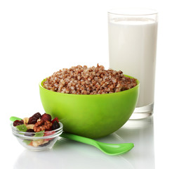 Boiled buckwheat in a green bowl a glass of milk isolated