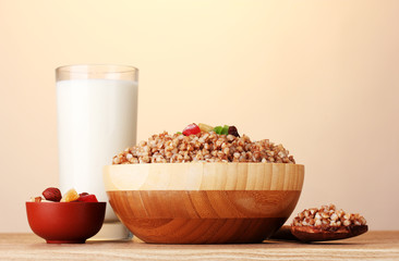 Boiled buckwheat in a wooden bowl with a glass of milk