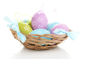 Colorful easter eggs in basket isolated on white