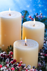 Three candles with snowfall
