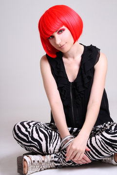 Young Woman In Red Wig Sitting