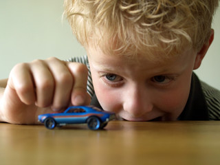 Boy playing with a toy car