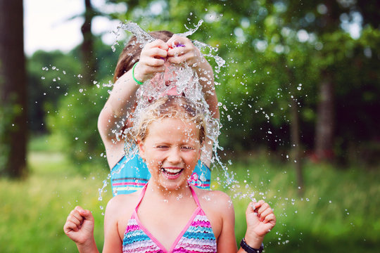 girls having fun outdoor with water balloons