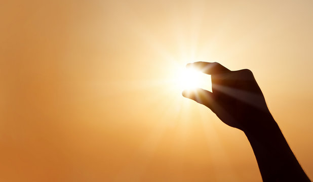 Male Hand Catching The Sun At Sunset With Copy Space