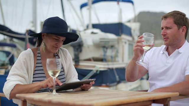 Young couple with tablet computer at marina, steadycam shot
