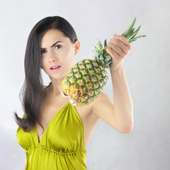 Zdenerwowana piękna kobieta z dojrzałym ananasem - obrazy, fototapety, plakaty