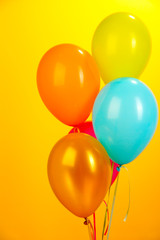 Fototapeta na wymiar colorful balloons on yellow background close-up