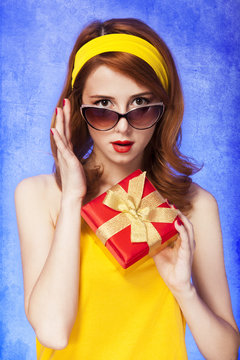 American redhead girl in sunglasses with gift.
