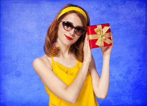 American redhead girl in sunglasses with gift.
