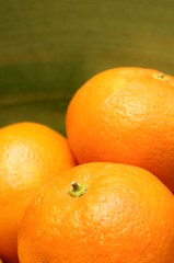 Close up of orange mandarins on green background