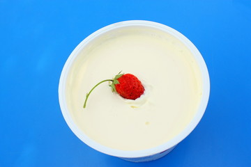 fraise dans un pot de crème fraîche