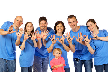 Family smiling while showing “We Love Family” on hands.