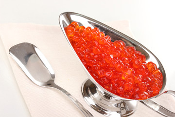 Red caviar in silver bowl isolated on white