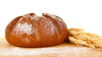 Homemade whole bread on wooden cutting board close-up