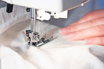 Hand sewing on a machine - obrazy, fototapety, plakaty